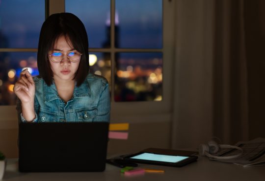 young woman looking at laptop screen suspiciously