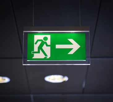 Emergency exit sign above a black doorway