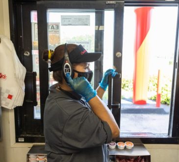 worker at fast food takeout window wearing headset