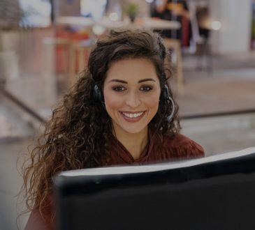happy female sales agent working at computer