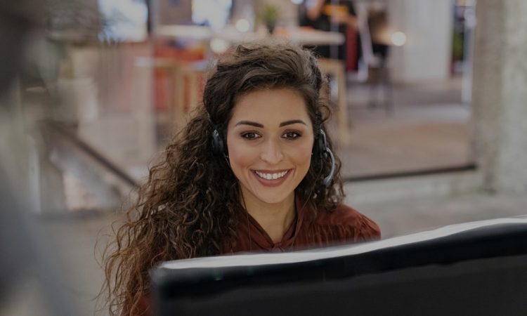 happy female sales agent working at computer