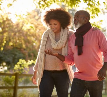 Senior Father With Adult Daughter on walk outside in fall