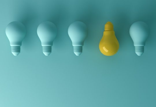 blue lightbulbs in a row with one yellow one facing the other way