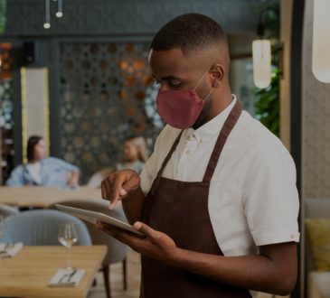 Waiter inside restaurant taking orders on ipad