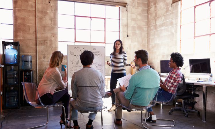 Group of people watching woman present in office