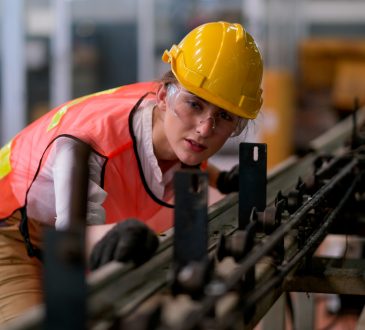 Woman working on machinery in factory.