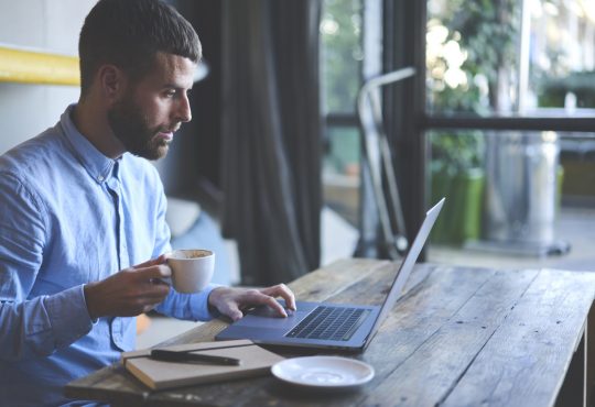 Man watching webinar on laptop.