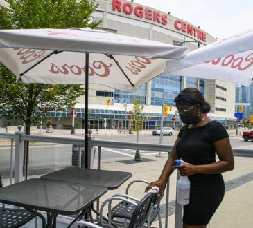 Female server wiping tables outside Rogers Centre in Toronto.