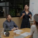 Woman giving presentation in front of colleagues in board room