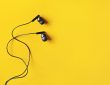 Black ear buds on yellow background