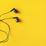 Black ear buds on yellow background