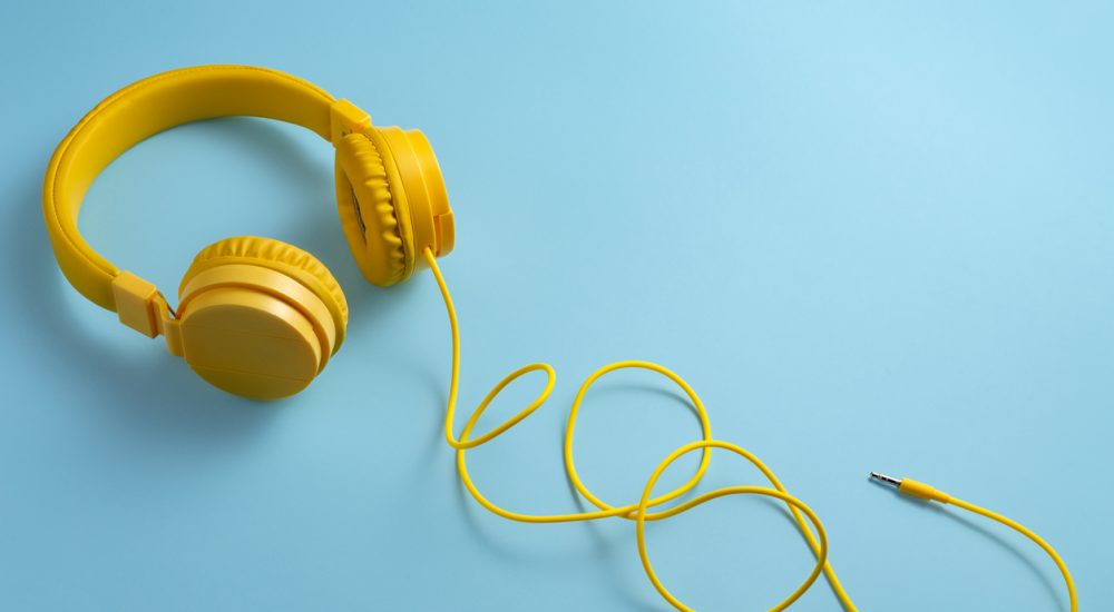 Yellow headphones on blue background.