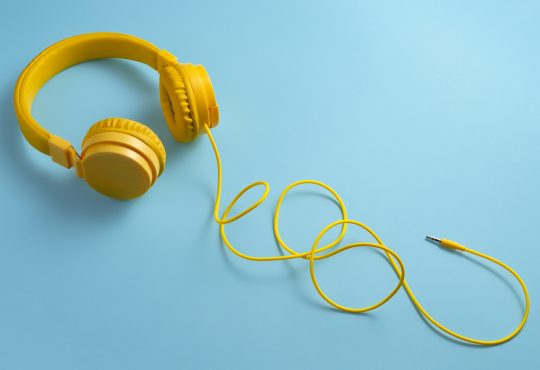 Yellow headphones on blue background.