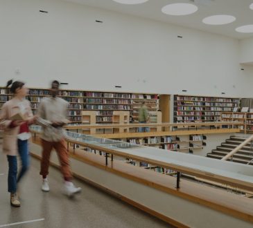 Students walking in college library.