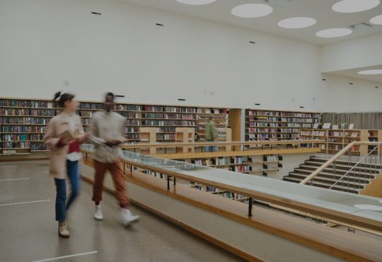 Students walking in college library.