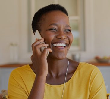 Woman smiling and talking on phone.