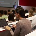 Adult student using laptop computer at a university lecture