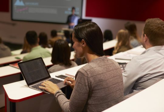 Adult student using laptop computer at a university lecture