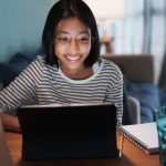 Girl smiling and looking at laptop