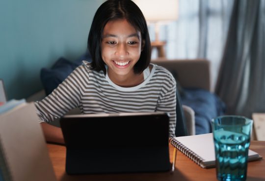 Girl smiling and looking at laptop