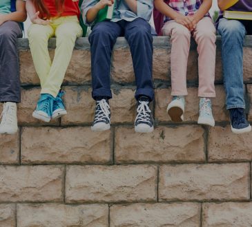 Youth sitting on brick wall
