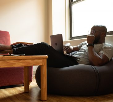 Man working on laptop sitting in beanbag chair