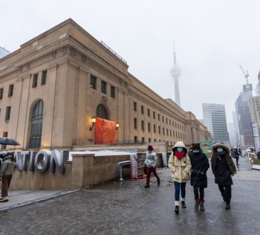 Pedestrians walking in front of the Union Station in Toronto on winter day.