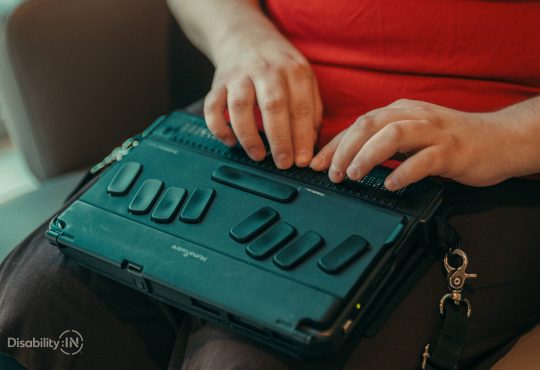 Closeup of woman's hands typing on braille keyboard