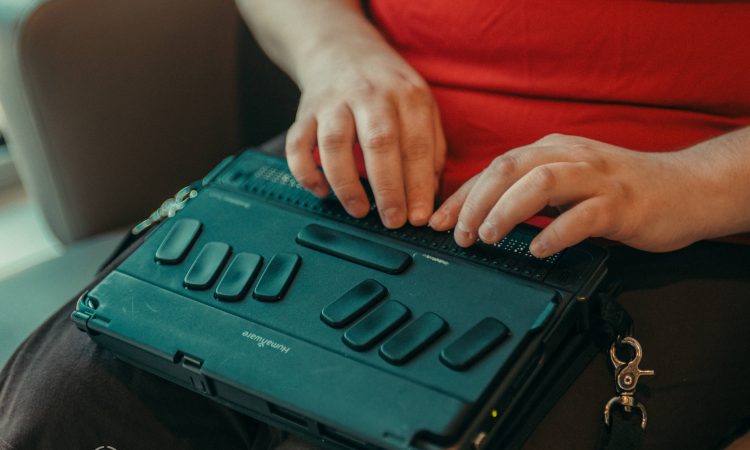 Closeup of woman's hands typing on braille keyboard