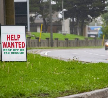 Help wanted sign beside road.