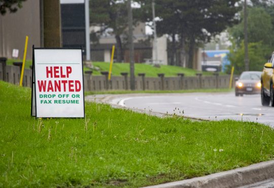 Help wanted sign beside road.