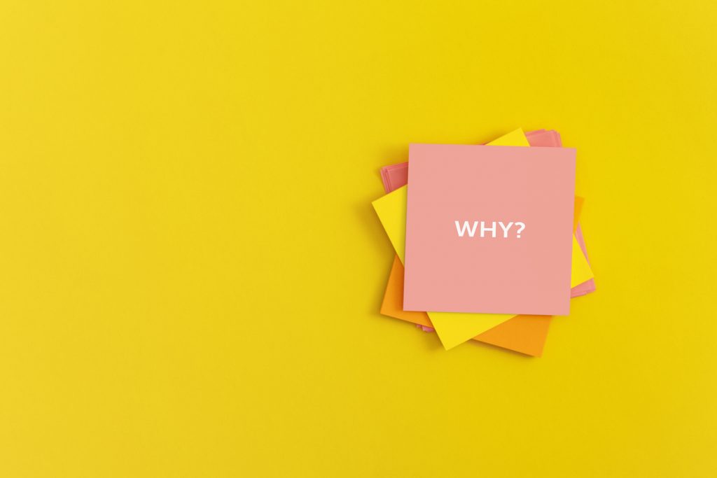 Sticky notes with word WHY on yellow background. 