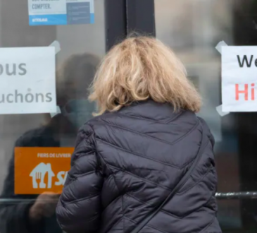Woman entering doors with hiring signs.