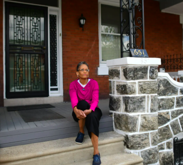Woman sitting on front steps of house