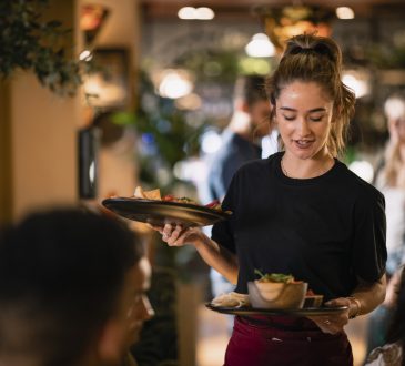 A waitress serving customers food at a restaurant