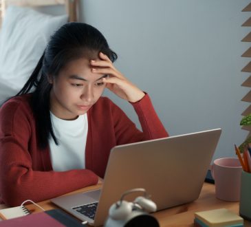 Stressed young woman looking at laptop