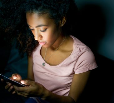 Girl texting on cellphone at night