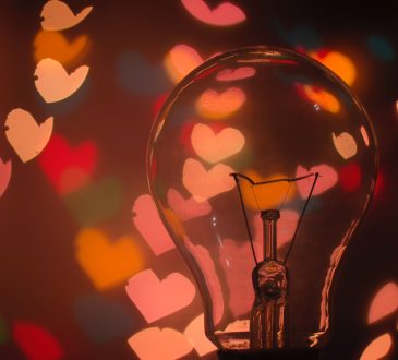 Lightbulb with hearts in background
