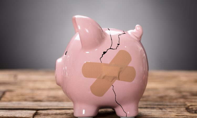 Closeup of broken pink piggybank with bandage