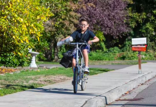 Boy delivering newspapers on bike