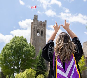 Western University graduate wearing convocation robes on campus