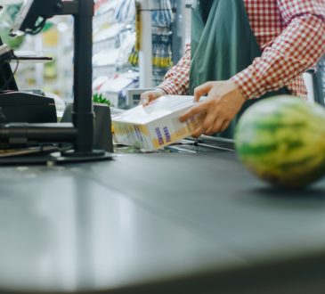 Hands of cashier scanning items at grocery stores