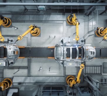 Aerial view of robot arms assembling cars in factory