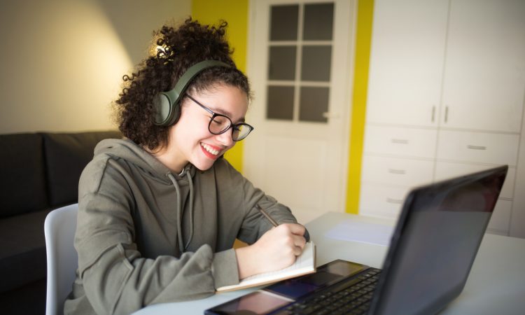 Young woman smiling while working on laptop