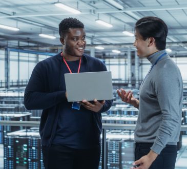 Two IT workers standing and talking in data centre