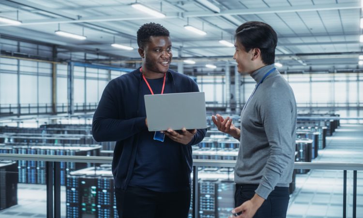 Two IT workers standing and talking in data centre