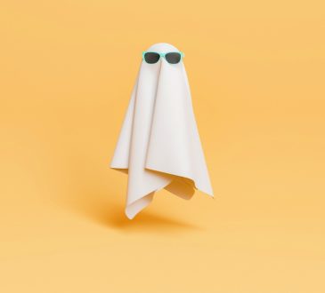 Ghost wearing sunglasses floating on yellow background
