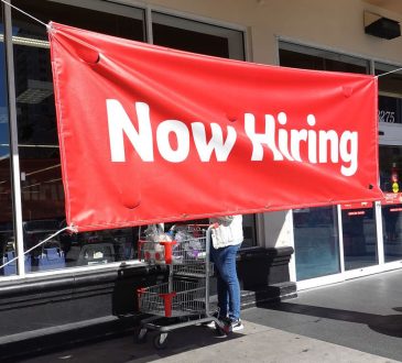 Now hiring banner in front of business