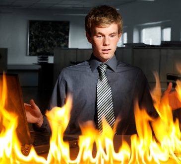 Man looking at desk on fire