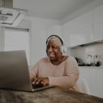 Older woman using laptop in kitchen